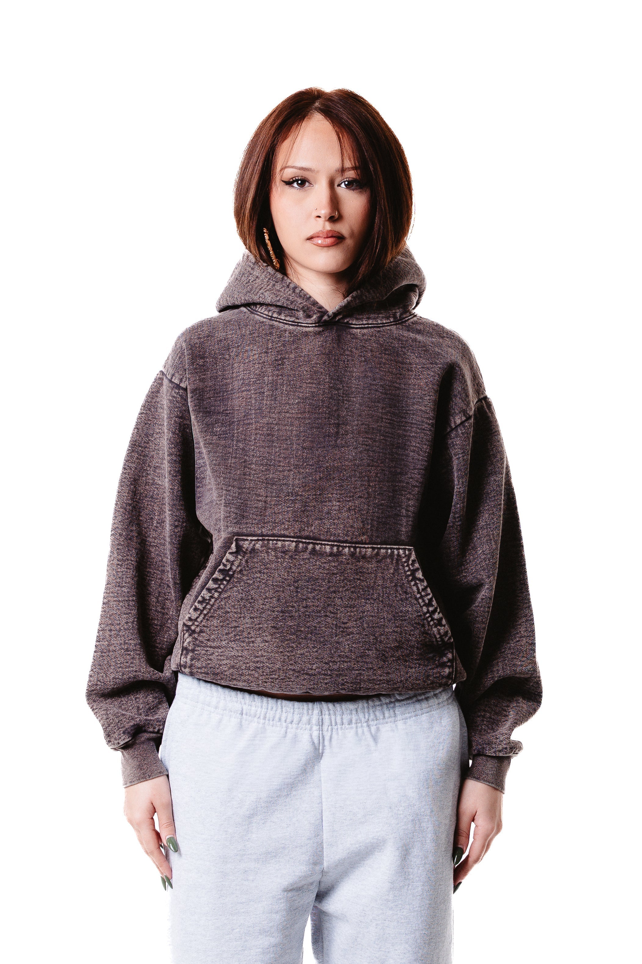 A young woman with straight brown hair wears the Mineral Wash Heavy Fleece Hoodie in dark brown and light gray sweatpants, standing against a white background with a neutral expression.