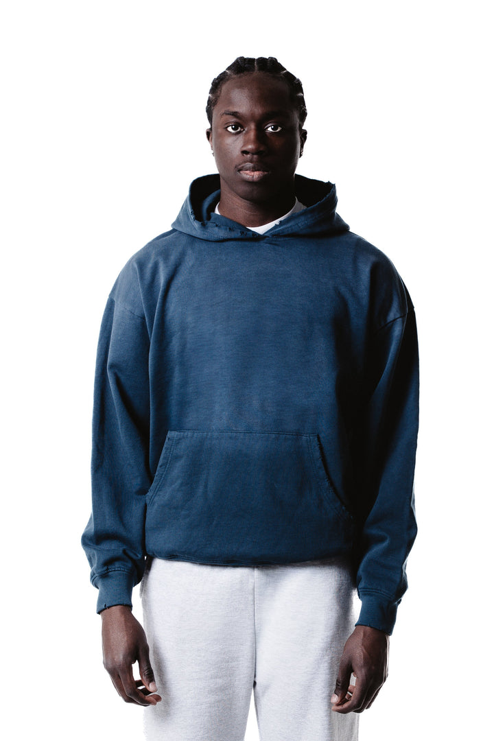 A person stands facing forward against a white background, wearing a blue Vintage Distressed Special Hoodie and light gray pants, with a neutral expression and hands relaxed at their sides.